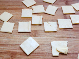 芝士土豆球,芝士片切成二厘米见方的小片，土豆泥趁热加入黄油，捣成泥状，加盐、黑胡椒粉搅拌均匀。