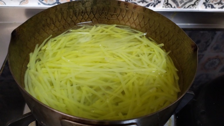 青椒炒土豆丝,煮至土豆丝透明，捞出备用。