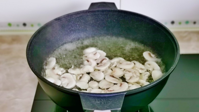 炒口蘑,口蘑下锅煮2分钟捞出。