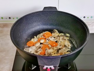 炒口蘑,加入蒜末炒香，加口蘑与胡萝卜片翻炒。