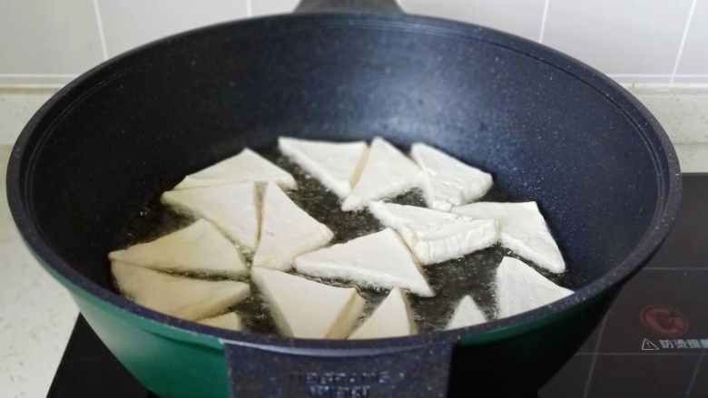 白菜炒豆腐,锅里放少许食用油，油热依次码入豆腐块，开中火慢慢煎，不要翻动。