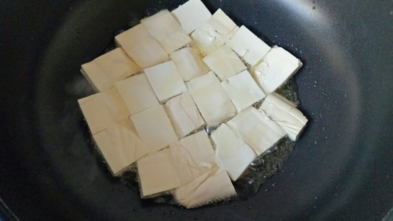 白菜炒豆腐,炒锅中放入适量花生油烧热，加入豆腐块，中小火慢慢煎至两面金黄