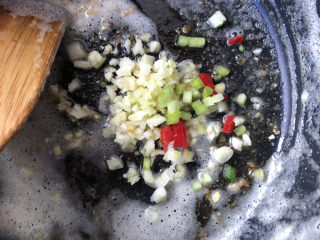 茄汁鹌鹑蛋,锅里的余油中，下入葱白、蒜末、尖椒煸炒出香味。