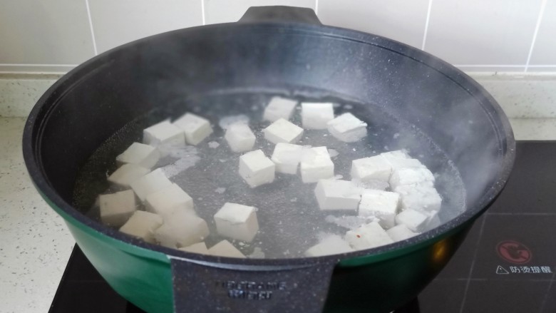 豆腐炒鸡蛋,锅里放适量的清水烧开，加一勺盐，放入豆腐块焯水【加盐焯水豆腐不容易碎。】