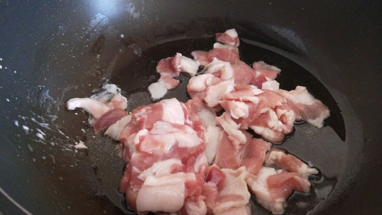 红烧米豆腐,五花肉切成片，放入锅中炒干出油。
