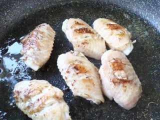 迷迭香风味烤鸡翅,6、放入鸡翅，煎至两面金黄。