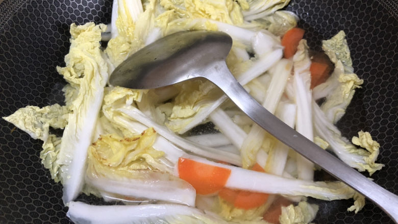 白菜炒豆腐,将白菜和胡萝卜倒入翻炒，然后加入适量水。