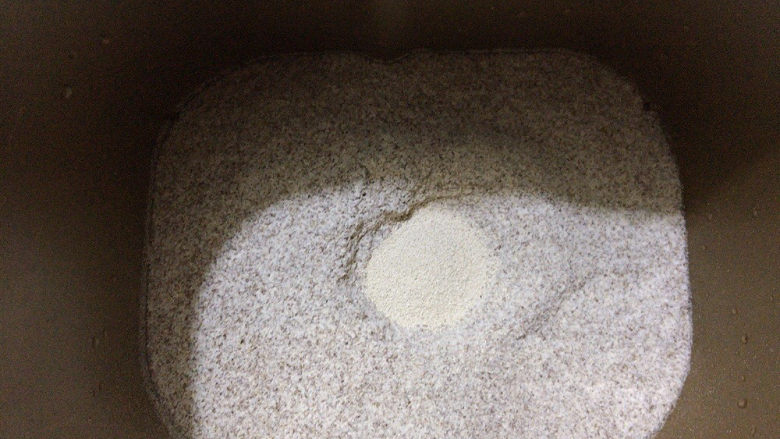 荞麦馒头,将面粉加入面包机中，启动和面模式，中间挖个小洞，加入五克的酵母。
