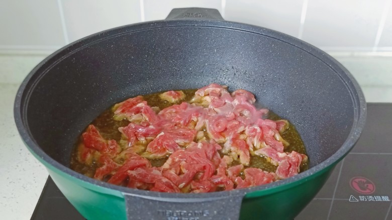 炒口蘑,锅里放适量的食用油，油温五成热放入牛肉丝爆炒。