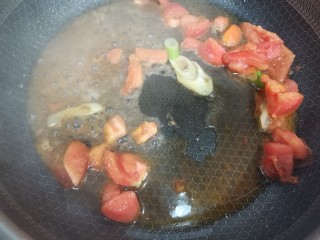 茄汁鹌鹑蛋,放入西红柿和大葱进行翻炒，西红柿炒软之后加入水。
