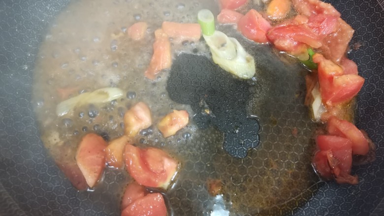 茄汁鹌鹑蛋,放入西红柿和大葱进行翻炒，西红柿炒软之后加入水。