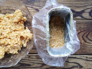 午餐肉饭团,在午餐肉盒子中套一层保鲜袋，压入适量抓拌好的米饭，一定要压实。