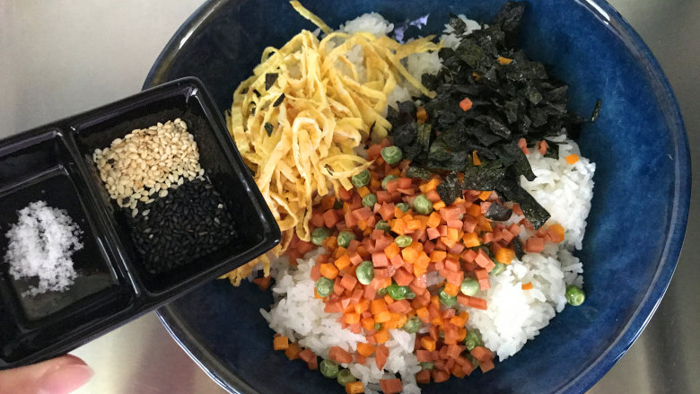 午餐肉饭团,把米饭、配菜全部放入大碗中，再放盐和黑白芝麻
