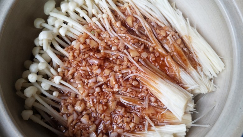 虾仁日本豆腐,将洗净的金针菇铺在砂锅底部，将煮开的蒜末料汁浇在金针菇上。