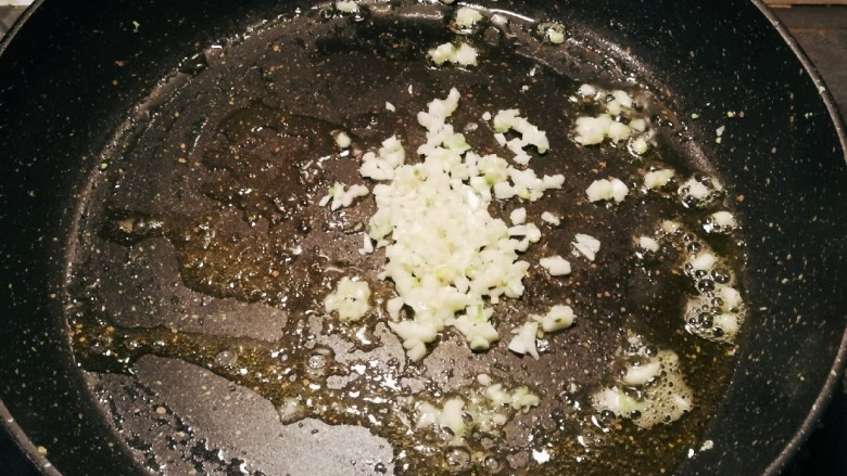 油豆腐炒青椒,起油锅放入食用油，油热后放入蒜碎炒香。
