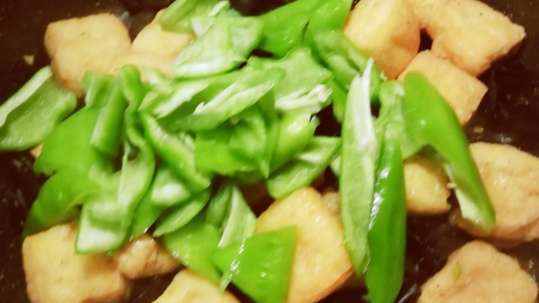 油豆腐炒青椒,放入青椒。