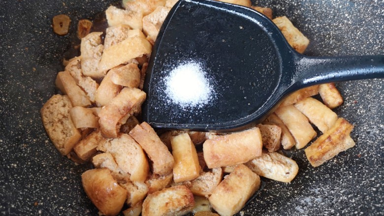 油豆腐炒青椒,放盐调味。