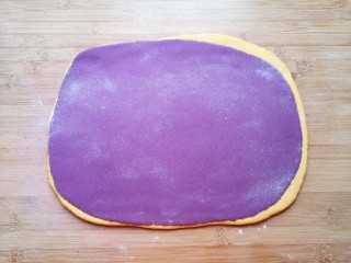 南瓜紫薯馒头,两种颜色的面团各取一份，擀成接近长方形的大面片摞起来，再次擀开。 