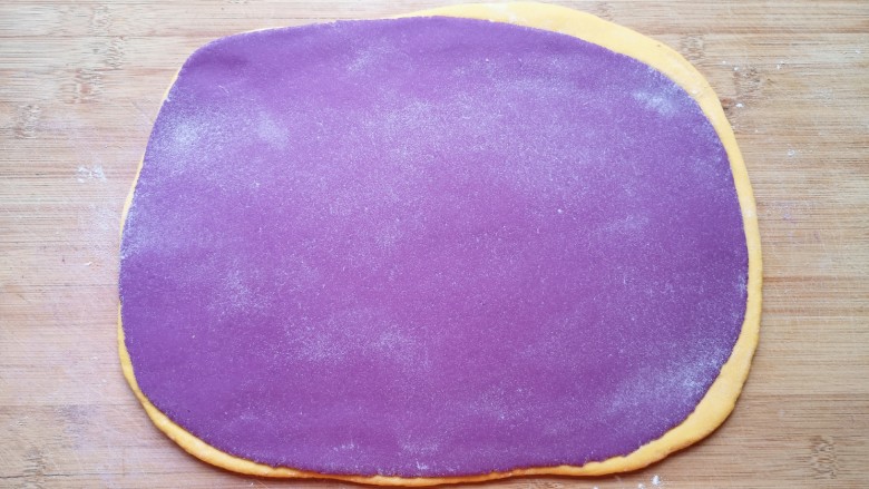 南瓜紫薯馒头,两种颜色的面团各取一份，擀成接近长方形的大面片摞起来，再次擀开。 