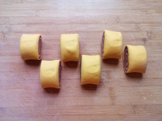 南瓜紫薯馒头,用刀切开，成一个个双色馒头。 