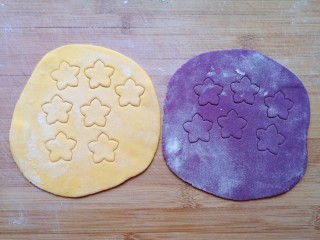 南瓜紫薯馒头,之前留出来的两种面团擀成薄薄的面片，用模具刻出花朵状。