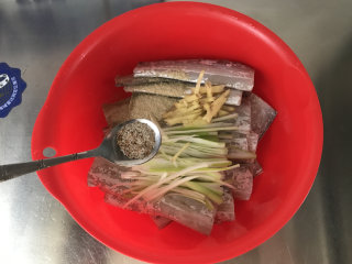干煎带鱼,碗中放入带鱼、料酒、葱姜丝、花椒粉和自制五香椒盐，腌制半小时