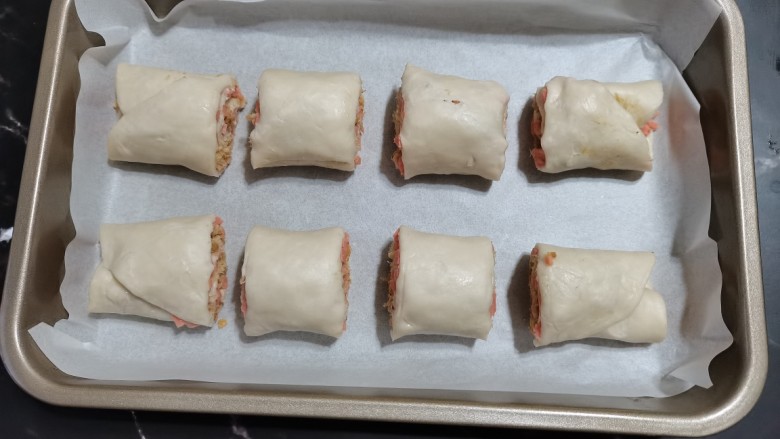 手抓饼版火腿肉松酥,烤盘底部放一层油纸，放上火腿肉松卷