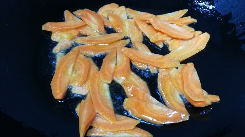 胡萝卜炒杏鲍菇,文火翻炒均匀，把胡萝卜稍微炒软。
