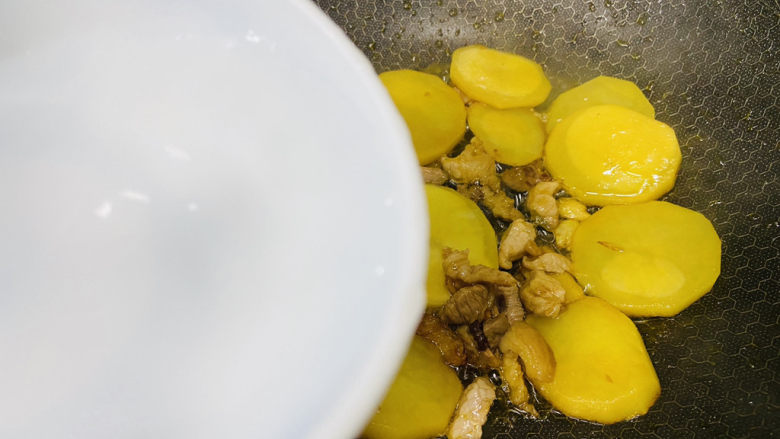 洋葱炒土豆片,沿着锅边淋入小半碗热水，炒熟
