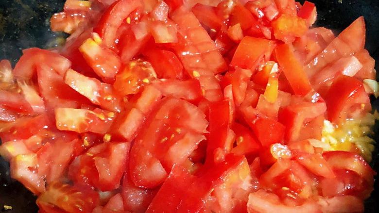 西红柿豆腐汤,锅中倒入底油加热放入蒜粒爆香再放入西红柿大火快速翻炒