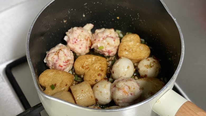 香辣口水火锅丸子,把调味料和各种丸子拌匀，装盘后再撒一些葱花点缀即可。