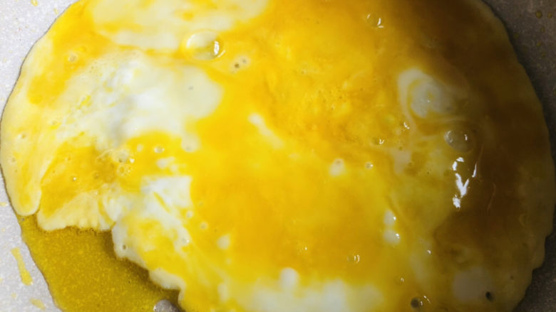 腊肠炒蛋,不粘锅倒入少许底油，油烧热后放入打散的鸡蛋快速炒成块状。