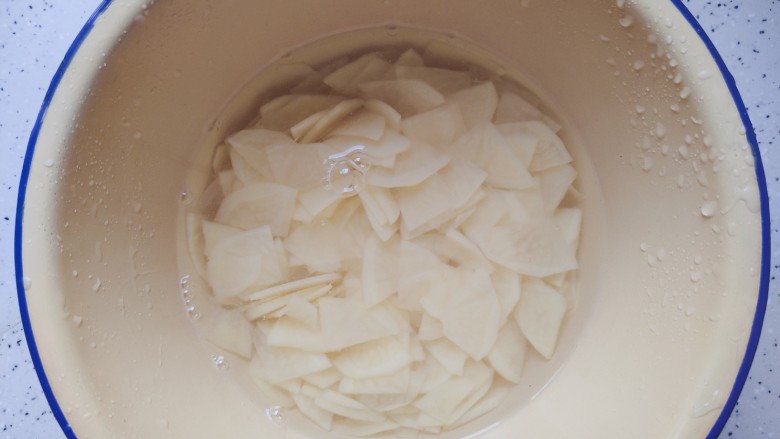 洋葱炒土豆片,然后用适量清水浸泡，以免土豆氧化变色