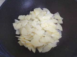 洋葱炒土豆片,待锅内油热，下土豆片儿（沥干水分）