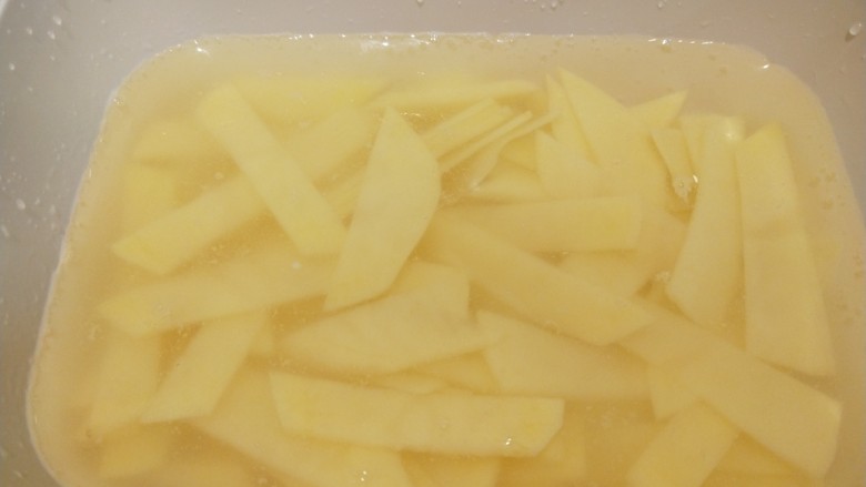 洋葱炒土豆片,放入容器泡水洗去淀粉。