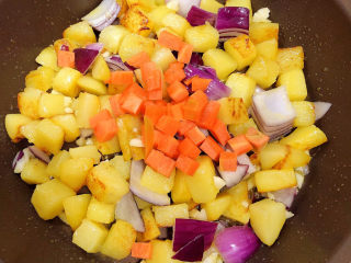 洋葱炒土豆片,放入胡萝卜丁，翻炒均匀。