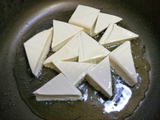 三鲜豆腐,锅中热油，放入豆腐小火慢煎。