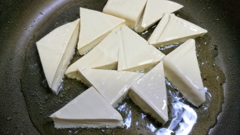 三鲜豆腐,锅中热油，放入豆腐小火慢煎。