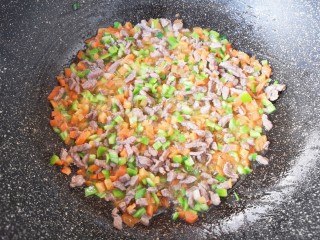 孜然羊肉炒饭,下入青椒翻炒均匀。