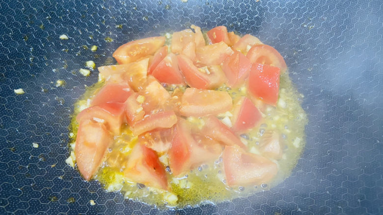 西红柿豆腐汤,放入西红柿翻炒至出汤汁