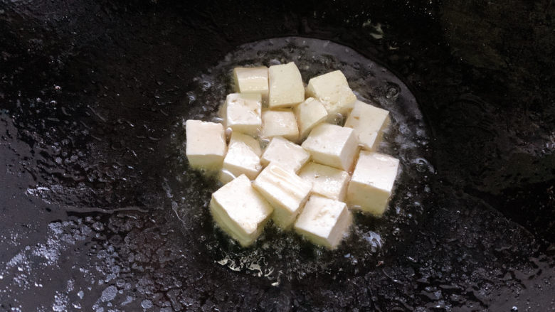 三鲜豆腐,加入豆腐块小火先煎一煎，煎制每面金黄，捞出备用。
