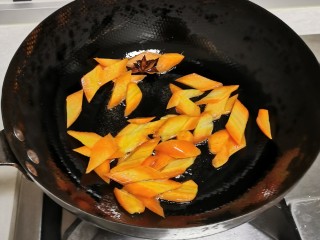 洋葱炒土豆片,起油锅，放入八角炒香后放入胡萝卜片翻炒断生。