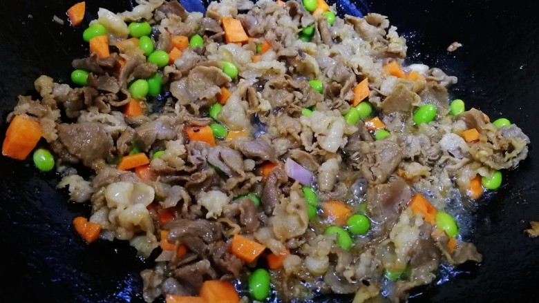 孜然羊肉炒饭,放胡萝卜丁，毛豆粒，文火炒匀。