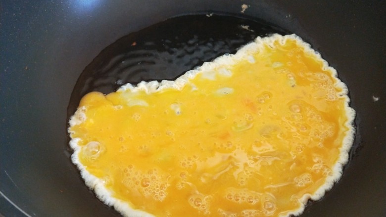 腊肠炒蛋,锅中倒入鸡蛋炒出鸡蛋块。