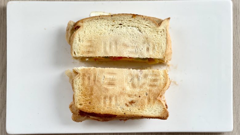 杂蔬蟹柳煎蛋三明治,最后把三明治从中间切开即可。