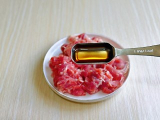 青椒炒牛肉,首先将牛肉片洗干净，再淋干水分放入盘中，加入料酒去腥。
