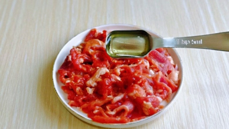 青椒炒牛肉,淋上一勺食用油，更能锁住牛肉的水分，抓拌均匀腌制20分钟。