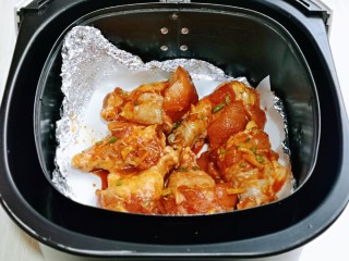 蜜汁烤鸡腿,腌制好的鸡腿，放入空气炸锅。(烤网上垫上油纸)