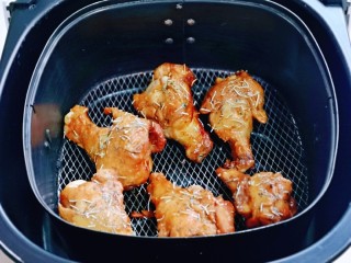 蜜汁烤鸡腿,把鸡腿夹放在烤网上，撒上迷迭香，185度再烤10分钟。