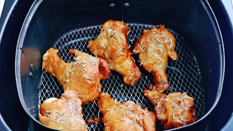 蜜汁烤鸡腿,把鸡腿夹放在烤网上，撒上迷迭香，185度再烤10分钟。